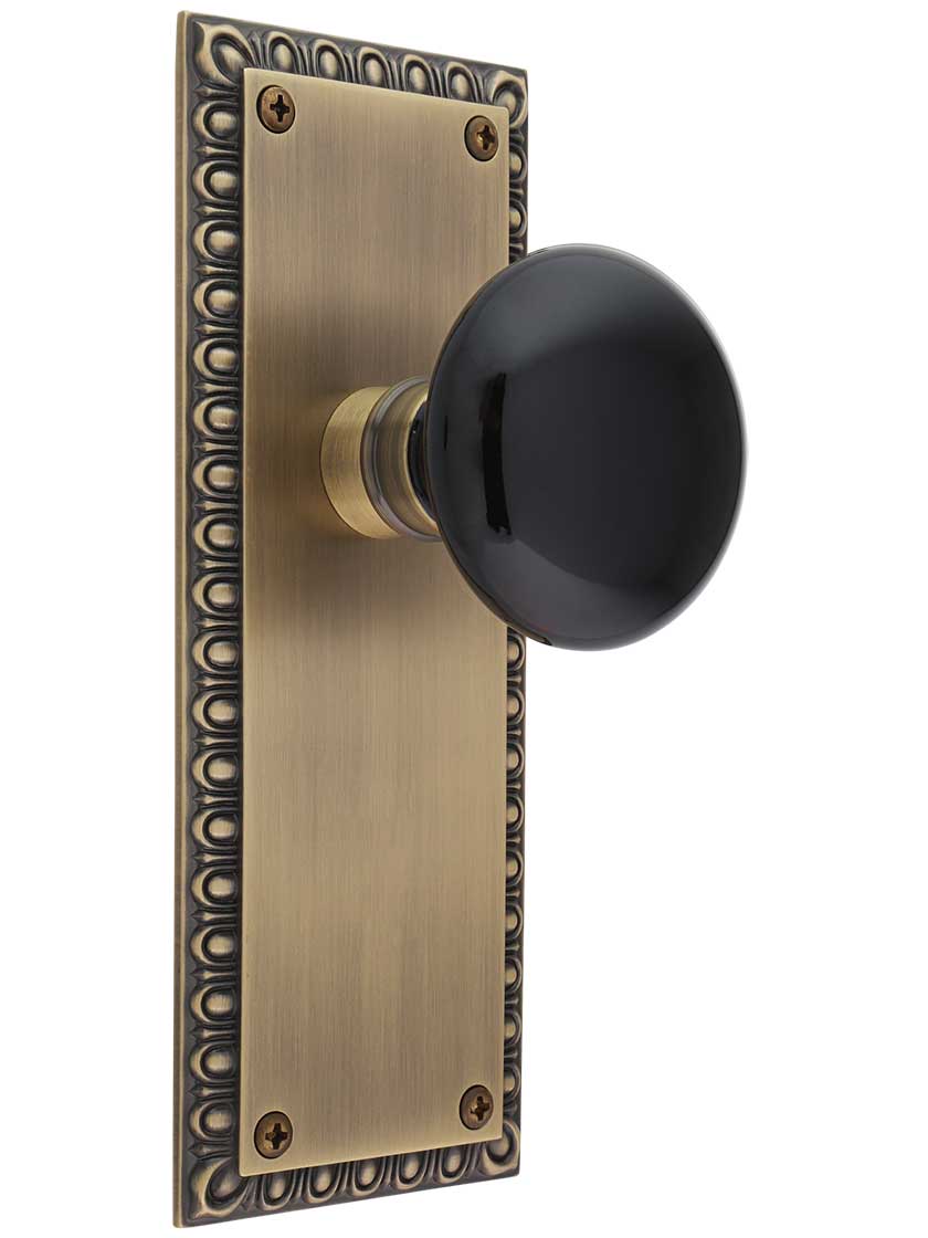 Ovolo Door Set with Black Porcelain Knobs in Antique Brass.